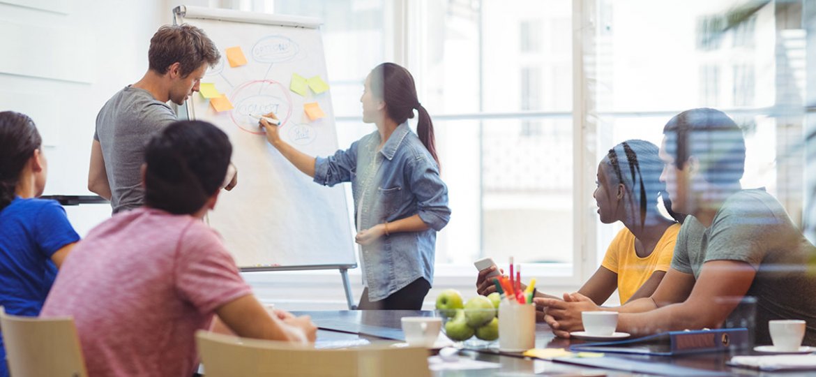 Business executives discussing with their colleagues on whiteboard