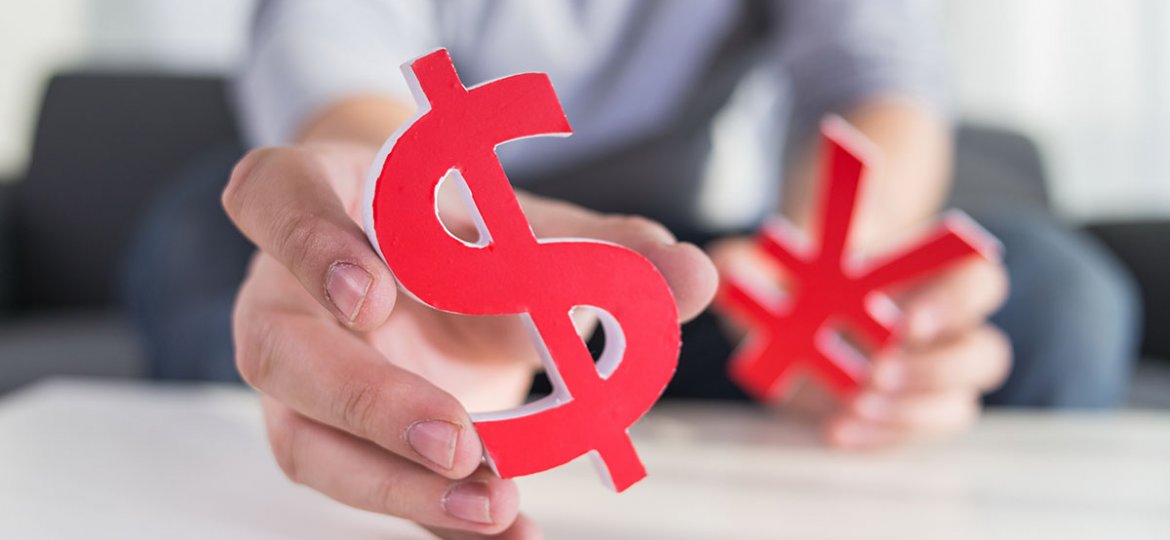 Businessman holding dollar sign and CNY sign