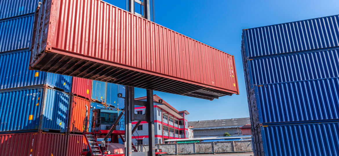 Truck forklift lifting loading heavy container cargo box at port container yard shipping logistics